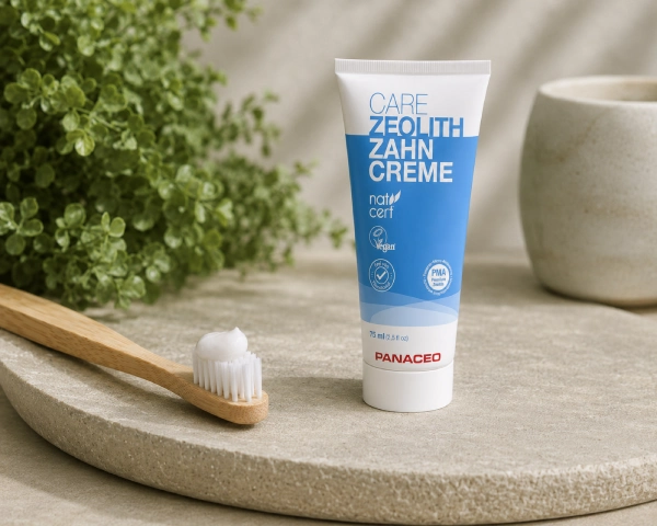 Anwendung der Panaceo Care Zeolith-Zahncreme – morgens und abends Zahnbürste mit einer erbsengroßen Menge Panaceo Care Zeolith-Zahncreme neben der geöffneten Tube