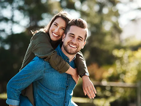 Happy couple on a walk – symbol of health and vitality through gut cleansing with PMA-Zeolite A young, smiling couple outdoors – she hugs him from behind. The image represents well-being and joy as supported by gut health with PMA-Zeolite.