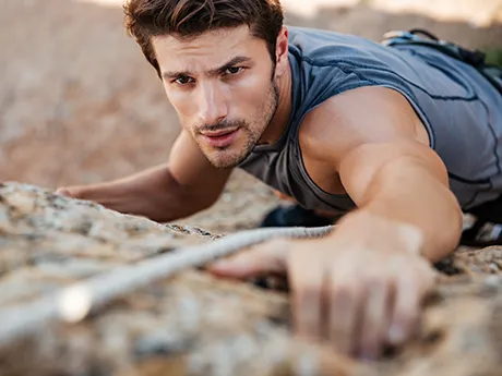 Natural support for athletes – PANACEO for performance and gut balance A fit man climbing outdoors. The image symbolizes strength, endurance, and natural performance supported by PANACEO during sports.