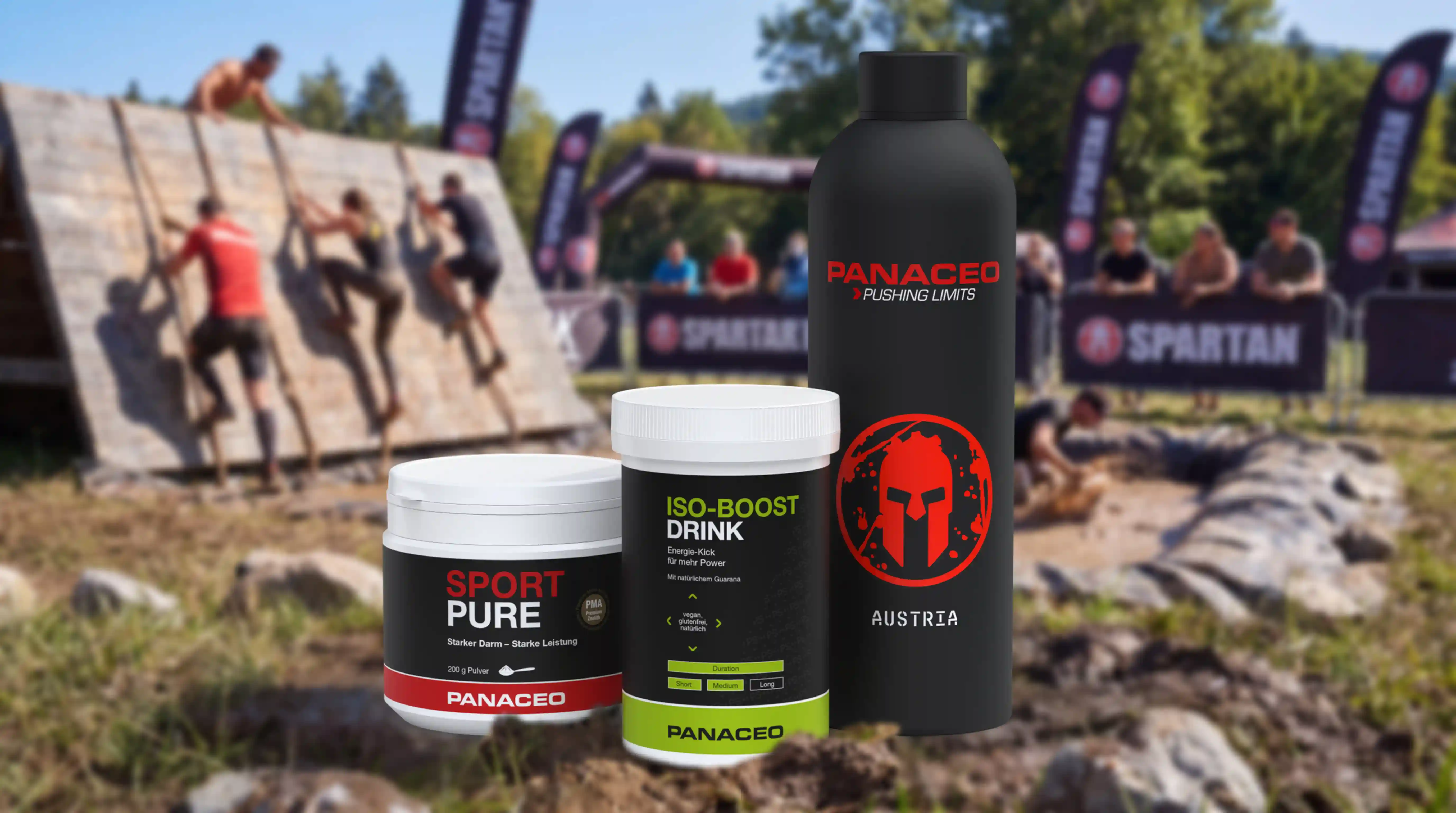 PANACEO Sport Pure, Iso-Boost Drink und schwarze Trinkflasche vor einem Spartan-Hindernislauf mit kletternden Teilnehmern